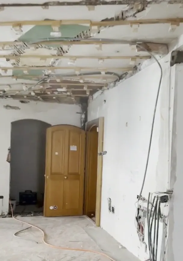 Avant : appartement en démolition, plafond ouvert, gaines apparentes.