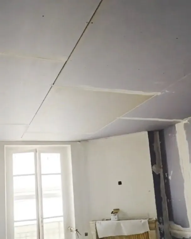 Avant : murs et plafond de l'appartement en cours de plâtrerie.