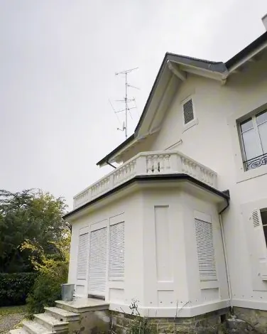 Après : la même villa, façade repeinte en blanc.
