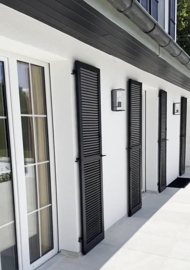 Après : façade blanche, volets anthracite, terrasse dallée.